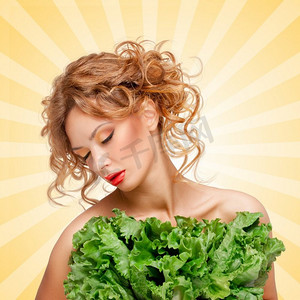 卡通蔬菜摄影照片_美丽的女孩正在节食，隐藏在生菜绿叶后面的卡通风格背景。