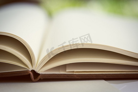 打开的书页摄影照片_合上打开的书页。已调..打开桌子上的书。关门了。