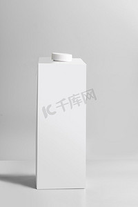 白色包装四包站在浅灰色背景，正面视图。空模板盒牛奶或果汁。包装品牌模型