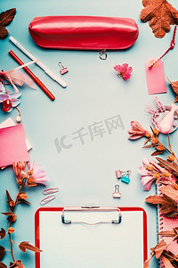 边框优雅摄影照片_现代女性家庭办公桌面为粉红色，蓝色背景上有鲜花和配件，俯视，边框。平躺，模拟。