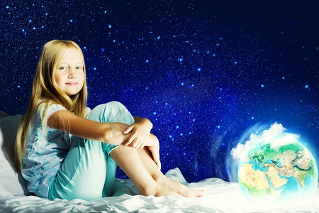 晚安。女孩坐在床上做梦。这张图片的要素由美国宇航局提供