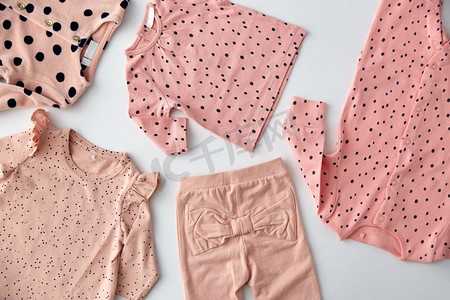 婴儿期和服装概念-粉色女婴衣服，白色背景上有圆点印花。白色背景的粉色女婴衣服