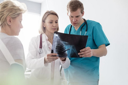 治疗摄影照片_物理治疗师在医院对护士和病人进行X光检查的讨论