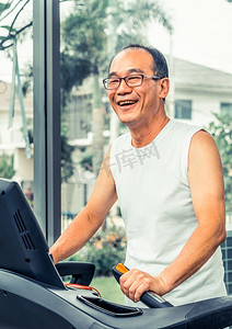 老年人在健身中心的跑步机上锻炼。成熟健康的生活方式..老年人在健身中心的跑步机上锻炼