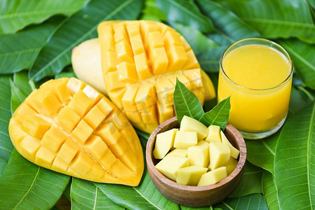 甜点背景摄影照片_甜成熟芒果/芒果汁杯与芒果片芒果叶从树热带夏季水果概念