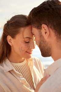 休闲，关系和人的概念—快乐的夫妇闭上眼睛在夏季海滩。快乐的夫妇与关闭的眼睛在夏季海滩
