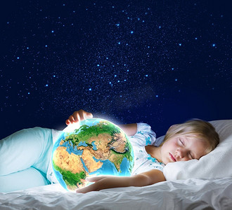 晚安你好手机海报摄影照片_晚安。女孩躺在床上，手里拿着地球。这张图片的要素由美国宇航局提供