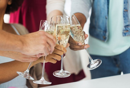 庆祝、人们和节日的概念-朋友们在派对上碰杯的特写。朋友们在派对上碰杯香槟