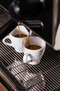 自动咖啡机煮出两杯香浓的咖啡。两杯咖啡