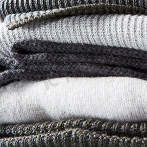白色背景上的一叠温暖的冬季针织毛衣。一叠暖和的冬季针织毛衣
