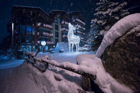 在寒冷的冬夜，阿尔卑斯山村的雪街上，