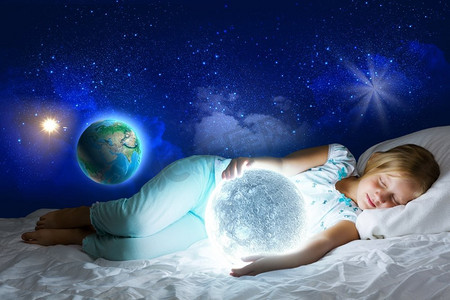 晚安。女孩躺在床上，手里拿着月亮。这张图片的要素由美国宇航局提供