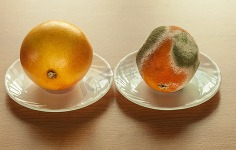 在木桌上的盘子里放着成熟发霉的葡萄干。健康水果和腐烂水果的区别。有机食品营养。