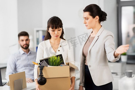 商业，解雇和失业概念—解雇悲伤的女性办公室工作人员与盒个人物品离开。解雇悲伤的女性办公室工作人员离开