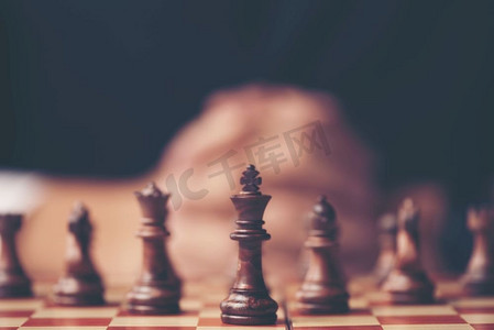 一个商人的复古风格形象有紧握的手计划战略与国际象棋数字在一张老木桌上。