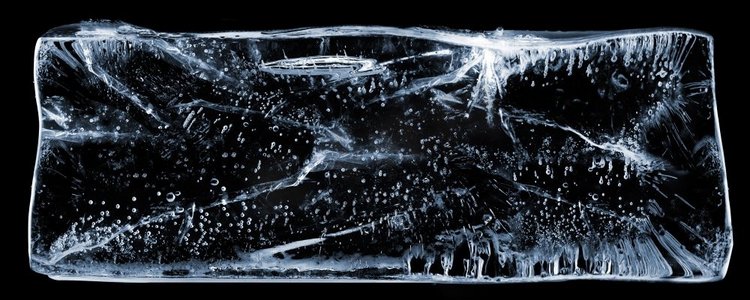 边形矩形图摄影照片_黑色的大矩形透明冰，上面有气泡。