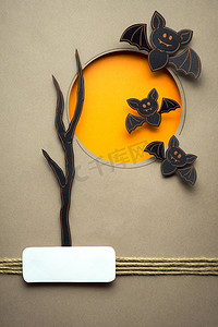 蝙蝠的创造性万圣节概念照片由纸制成在棕色背景。