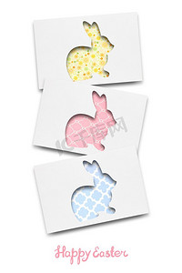 三只白纸兔子的创意复活节概念照片。