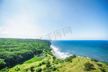 海景在一个山谷在海边与绿色森林和草地