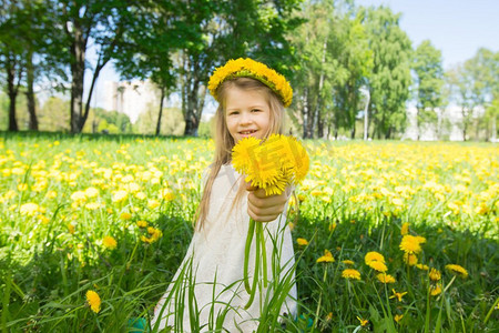女孩与花头花环和束。甜蜜的小女孩花头花环和鲜花束在手在夏天公园