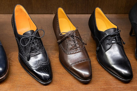 黑色和棕色全粒面皮鞋在男鞋精品店的木质陈列中..男士鞋类精品店