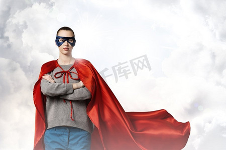 女超人摄影照片_她是女超人。年轻自信的女人，穿着红色斗篷，戴着面具