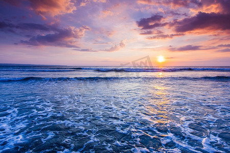 波巴摄影照片_阳光明媚的海滩日落。印度尼西亚巴厘岛，印度尼西亚，辐射五颜六色的海滩日落