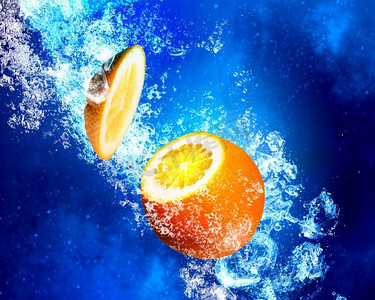 多汁的橙子泡在水里。橙色水果在清澈的蓝色水中飞溅