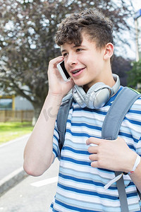 男生聊天摄影照片_男生十几岁学生在大学大楼外讲手机