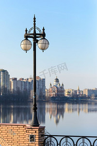 一盏路灯靠近河流与建筑物和教堂的背景