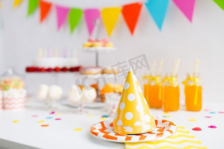 生日和节日概念—派对帽，食物和饮料上桌。生日派对帽，食物和饮料