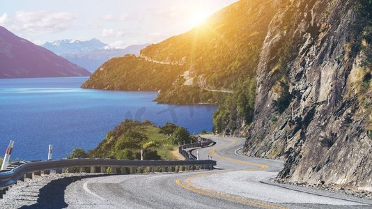 相约新西兰摄影照片_新西兰南岛昆斯敦，沿着山崖和湖泊景观蜿蜒的道路。夏季旅行和自驾游。