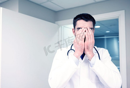 人，医学，保健和悲伤的概念-医院病房里悲伤或哭泣的男医生。医院病房里悲伤或哭泣的男医生