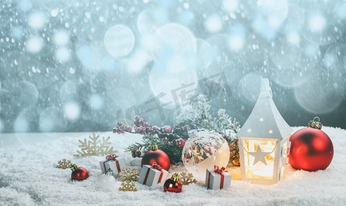 圣诞节文本框摄影照片_圣诞节假期卡与礼物，球，和发光灯笼在雪。圣诞装饰在雪