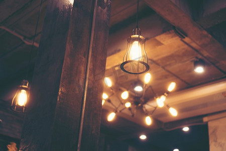 爱迪生灯泡摄影照片_装饰古色古香的爱迪生风格灯泡衬托着咖啡馆的墙壁