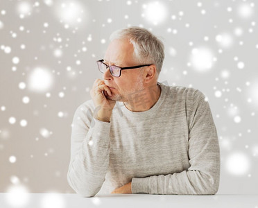 人的年龄摄影照片_老年、问题和人的观念--戴眼镜的老人在雪中思考的特写。戴眼镜的老人思考特写