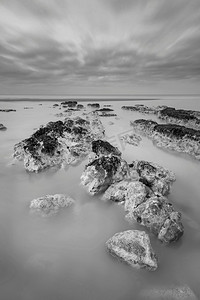 涟漪图片摄影照片_美丽的黑白长曝光日出时有岩石的低潮海滩风景图片