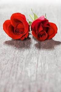 心形玫瑰。情人节，木质背景上的两朵心形红玫瑰