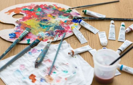 美术、创意和艺术工具概念-调色板、画笔和桌子上的画管。桌子上的调色板、画笔和画管