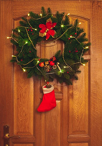 门上挂着红色袜子的圣诞花环。门上挂着圣诞花环