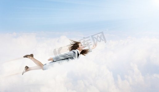 会飞的女超人。年轻漂亮的女商人在蓝天上飞翔