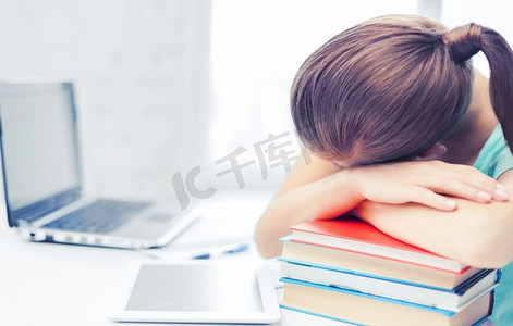 商业理念摄影照片_商业、办公室、学校和教育理念-疲惫的学生睡在书本上。疲惫的学生睡在书堆上
