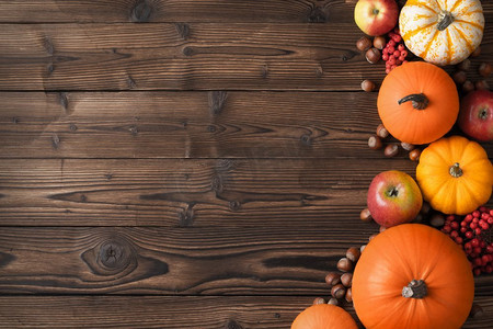 秋收在木桌上。秋收静物，木质背景上有南瓜、苹果、榛子和杨梅，俯瞰