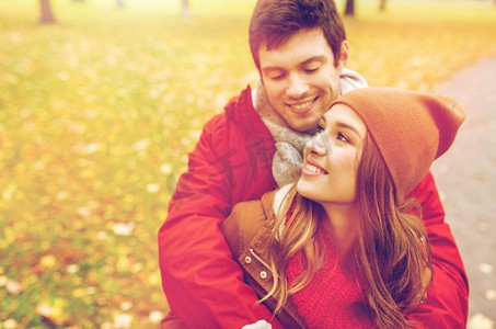 爱情，关系，季节和人的概念-秋天公园里幸福的年轻情侣拥抱。幸福的年轻情侣在秋季公园拥抱