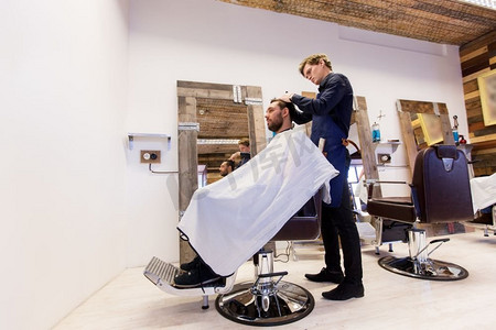 理发店理发摄影照片_理发、理发和人的概念-理发师和理发师在理发店理发。一名男子和理发师在理发店理发