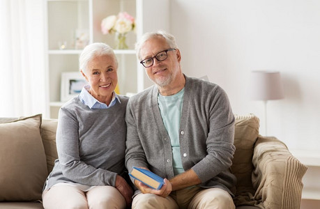 老年沙发摄影照片_关系、老年和人概念-愉快的资深夫妇坐在沙发在家。愉快的资深夫妇坐在沙发在家