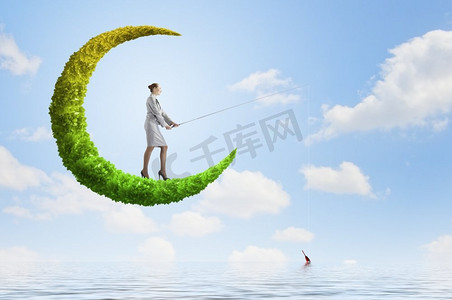 钓鱼的概念。女商人在绿色的月亮上用鱼竿钓鱼