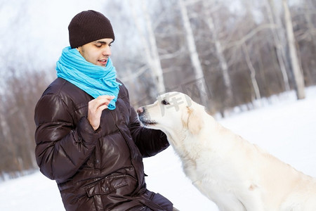 他最好的朋友。家伙与拉布拉多犬在冬季公园散步