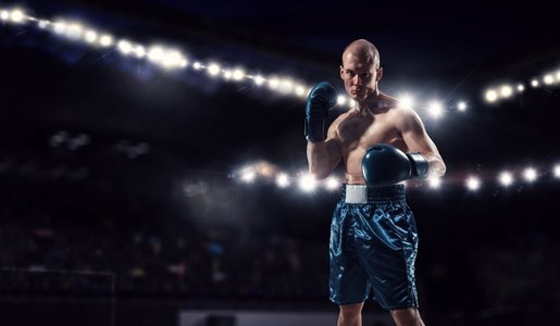拳击手摄影照片_职业拳击冠军。职业拳击手在聚光灯下混杂媒体在竞技场上战斗