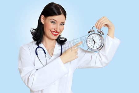 年轻的女医生与时钟。肖像快乐的成功的年轻女医生拿着时钟